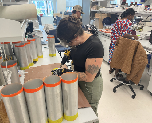 People working with soil cores and equipment at laboratory benches.